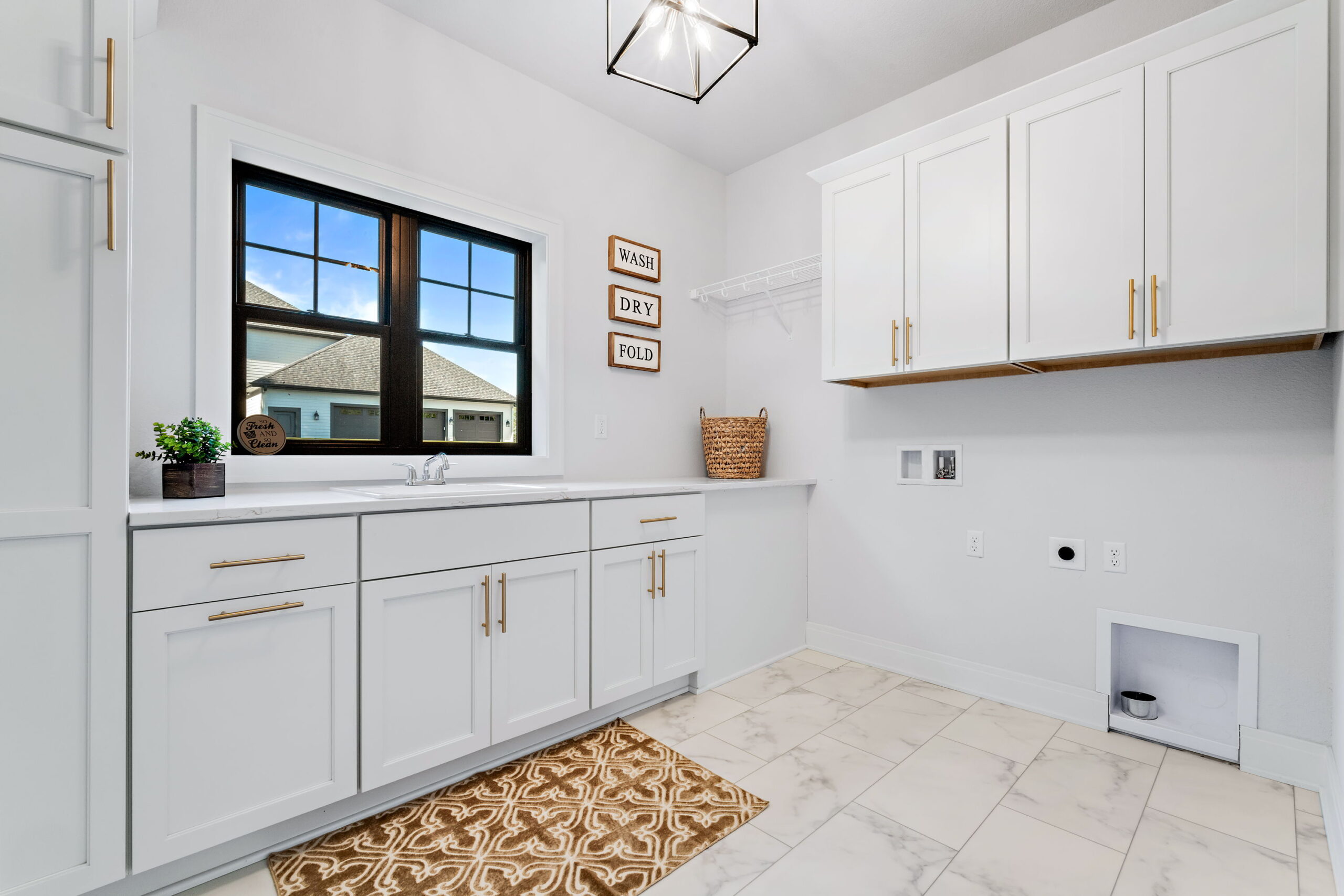 Laundry room with white cabinets, countertop workspace, sink, and upper storage