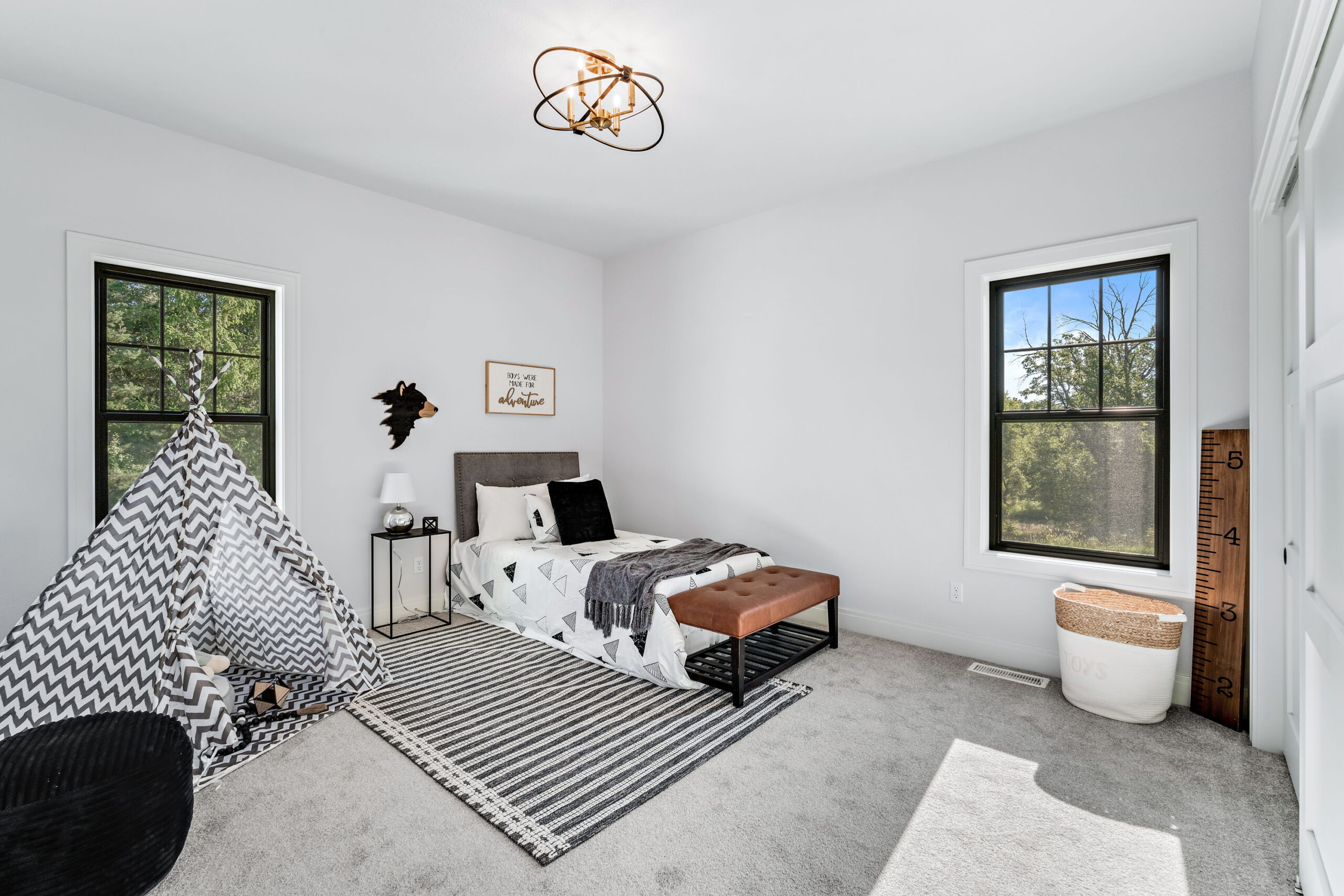 Kids bedroom with twin bed, play tent, accent rug, and natural light from windows